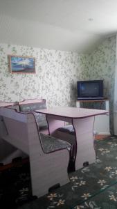 a room with a table and chairs and a tv at Guest House Olga in Kaji-Say +23 photos