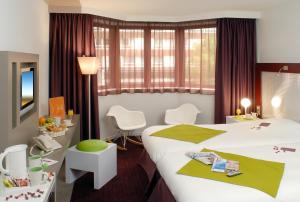 a hotel room with a bed and a table and chairs at Mercure Strasbourg Centre in Strasbourg