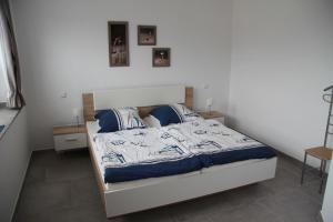 1 dormitorio con 1 cama con sábanas azules y blancas en Ferienwohnung Am Anker in Bislich, en Wesel