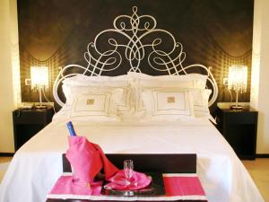a bedroom with a large white bed with a pink tray at Cassisi Hotel in Milazzo