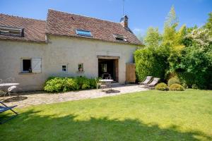 a house with a yard with a table and chairs at Le Clos du Verger in Levernois