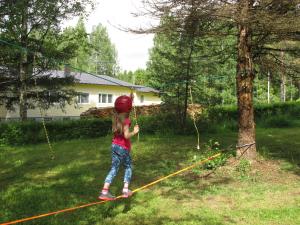 a little girl standing on a rope in a yard at Fireman Center in Saari