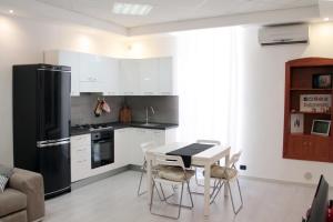 a kitchen with a table and a black refrigerator at Casa 1941 in Conversano