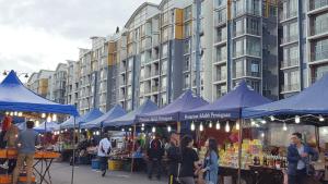 een groep mensen die rondlopen op een markt met blauwe tenten bij Feel Homestay in Cameron Highlands