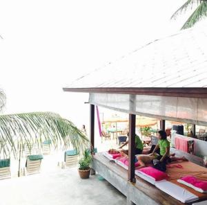 a group of people sitting on beds on the beach at Marina Villa in Lamai
