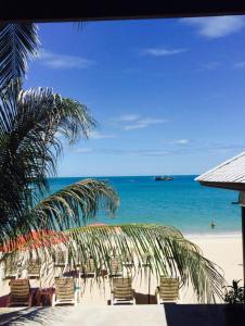 uma praia com cadeiras e uma palmeira e o oceano em Marina Villa em Lamai