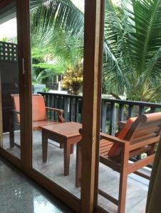 um quarto com um pátio com uma cadeira e uma mesa em Marina Villa em Lamai