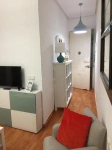salon z krzesłem i telewizorem w obiekcie Apartamento Vive en Maravillas w Madrycie +13 zdjęć