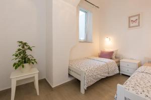 a small bedroom with two beds and a window at Villa Belsito in Lovran