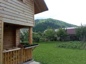 a wooden cabin with a yard and a field of grass at Sadyba Sukhar in Kolochava