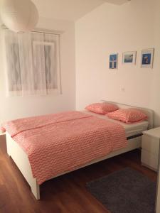 Un dormitorio con una cama con sábanas rojas y una ventana en L&L Apartments, en Vir