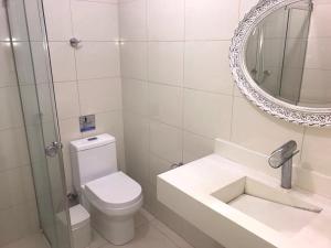 a bathroom with a toilet and a sink and a mirror at Hostel Flor de Maria in Sao Paulo