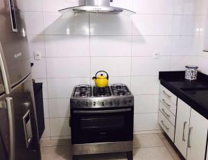 a yellow tea kettle on a stove in a kitchen at Hostel Flor de Maria in São Paulo