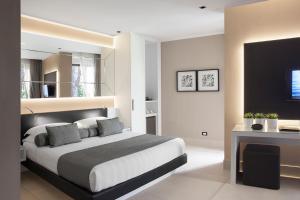 a bedroom with a large bed and a television at Riva Del Sole Resort & SPA in Castiglione della Pescaia