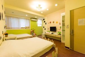 een slaapkamer met 2 bedden en een tv. bij Tainan Minuet in Tainan
