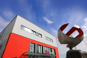 um edifício vermelho e branco com um grande objecto metálico à sua frente em 3G Hotel em Fulda