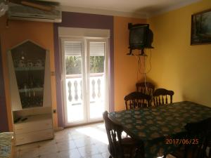 a dining room with a table and a television and a door at Apartments Drago in Petrcane