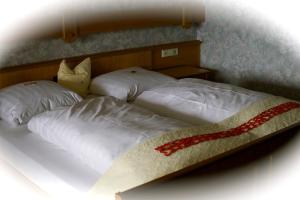 a bed with a white comforter and pillows at Hotel - Reweschnier in Kusel