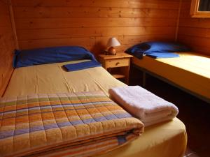 a bedroom with two beds and a table with a lamp at Camping El Pasqualet in Caldes de Montbui