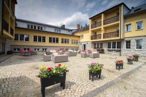 un patio con sofás y flores frente a un edificio en Hotel Biathlon Sport & Spa en Szklarska Poręba