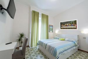 Schlafzimmer mit einem Bett, einem Schreibtisch und einem TV in der Unterkunft Bed & Breakfast Antonello in Salerno