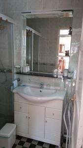 a bathroom with a sink and a mirror and a toilet at Gîtes sains Baie du mont saint Michel LES HORTENSIAS in Sains