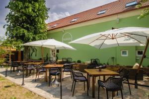 a patio with tables and umbrellas in front of a building at Penzión Kúria in Nové Mesto nad Váhom