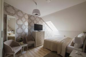 a bedroom with a bed and a tv on the wall at Penzión Kúria in Nové Mesto nad Váhom