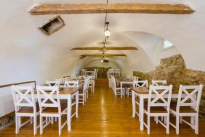 a dining room with tables and white chairs at Penzión Kúria in Nové Mesto nad Váhom