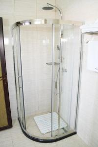 La salle de bains est pourvue d'une douche avec une porte en verre. dans l'établissement Hotel Clas, à Eforie Nord