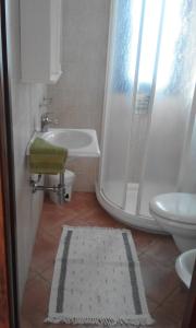 y baño con ducha, aseo y lavamanos. en Monolocale con giardino, en Castiglione della Pescaia