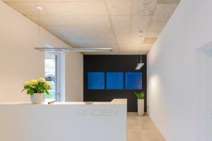 an office with a reception counter and blue screens at GADEN Apartment - Hotel in Waging am See