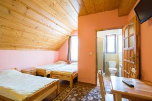 KacwinにあるDom Wypoczynkowy Martaのベッド2台とバスルームが備わる小さな客室です。