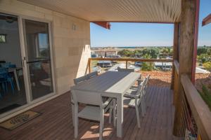 a wooden deck with a table and chairs on a balcony at Peoples Park in Coral Bay