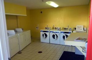 een wasruimte met wasmachines en drogers in een kamer bij Stay Inn & Suites - Stockbridge in Stockbridge