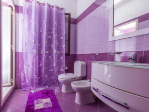 a purple bathroom with a toilet and a sink at Villa Giovanna in Arenella