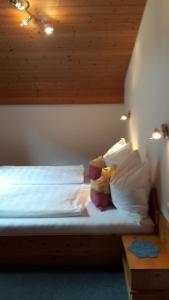 een slaapkamer met een bed met witte lakens en kussens bij Apart Martina in Ried im Oberinntal