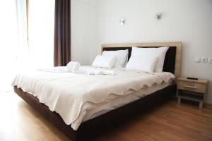Hotel Korab Trnica في Trnica: غرفة نوم بسرير كبير عليها شراشف ووسائد بيضاء