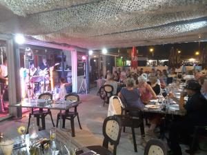 een groep mensen die aan tafel zitten in een restaurant bij Hotel Restaurant Calypso, à 10 m de la plage in Fos-sur-Mer