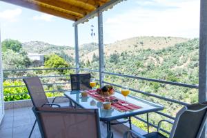 a table with two glasses of orange juice on a balcony at Ortaki Traditional House in Loúlos