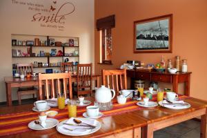 Mossel Bay的住宿－Avenues Guesthouse，用餐室配有木桌和食物