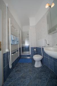a blue tiled bathroom with a toilet and a sink at Apartman Bianca the Best in Rijeka