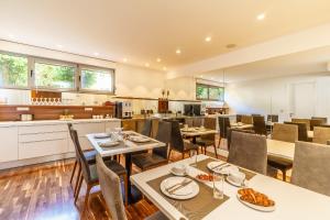 um restaurante com mesas e cadeiras e uma cozinha em Rooms Oasis Life em Split