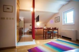 a living room with a table and a colorful rug at House Koloc in Bol
