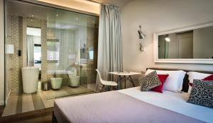 a hotel room with a bed and a bathroom at Teku Sardinia Boutique Hotel in Bari Sardo