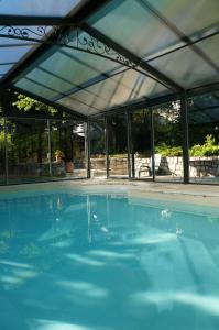 a large swimming pool with a canopy over it at la maison des chartreux in Brives-Charensac