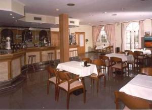 a restaurant with tables and chairs and a bar at Hotel San Vicente in Santiago de Compostela