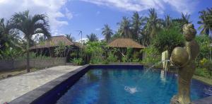 a swimming pool in front of a house with a fountain at Lembongan Bagus Villa in Nusa Lembongan