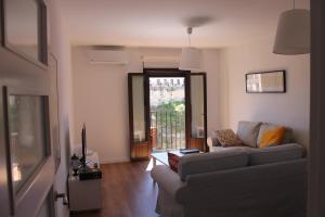 sala de estar con sofá y ventana en Buenavista Apartment en Ronda