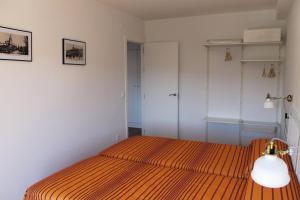um quarto com uma cama com uma colcha de listras laranja em Buenavista Apartment em Ronda
